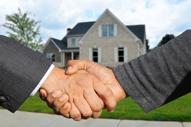 shaking hands infront of a house