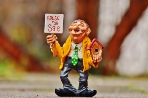 model of a man holding a for sale sign